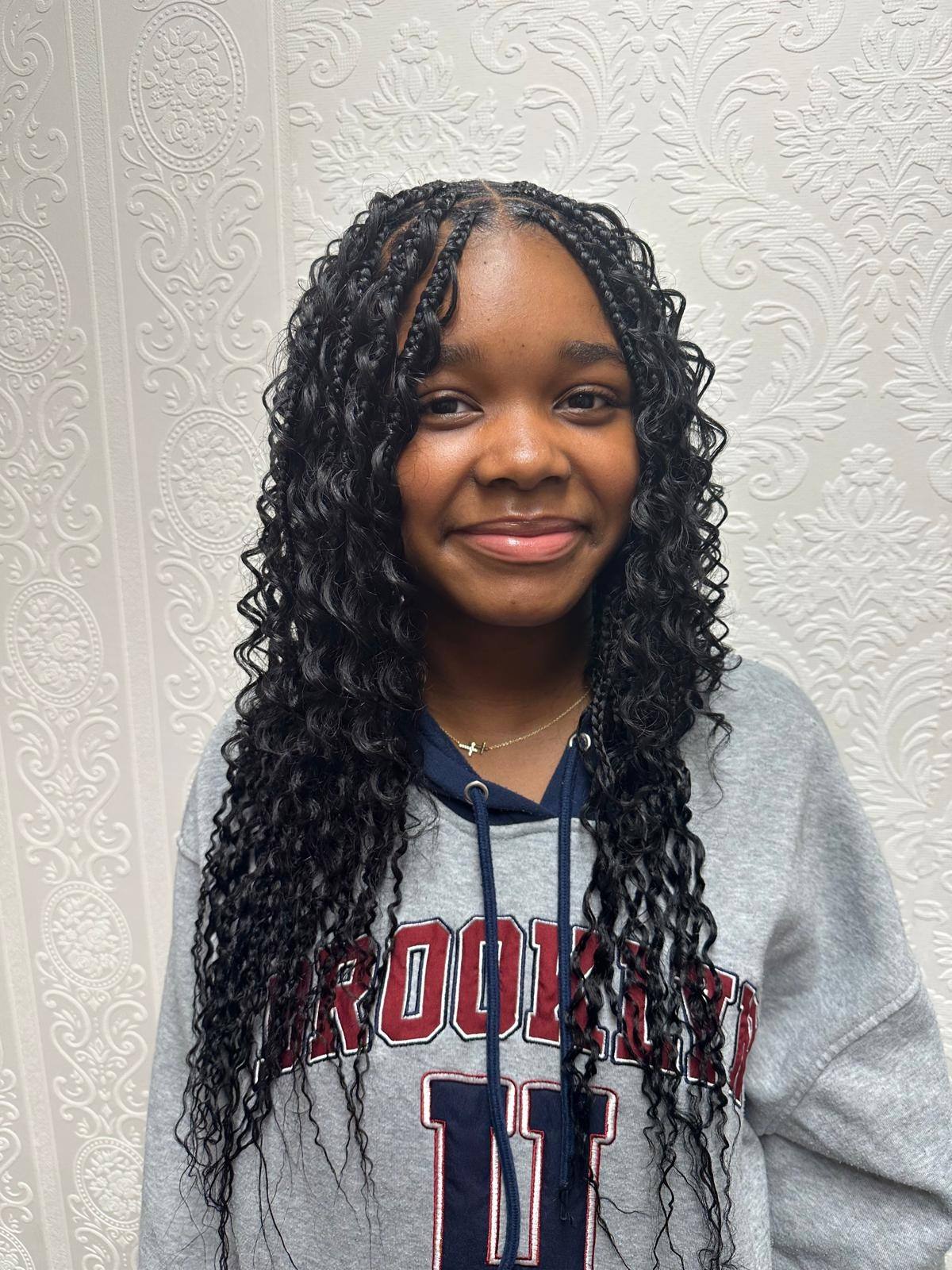Young client with boho braids and curly ends, front view