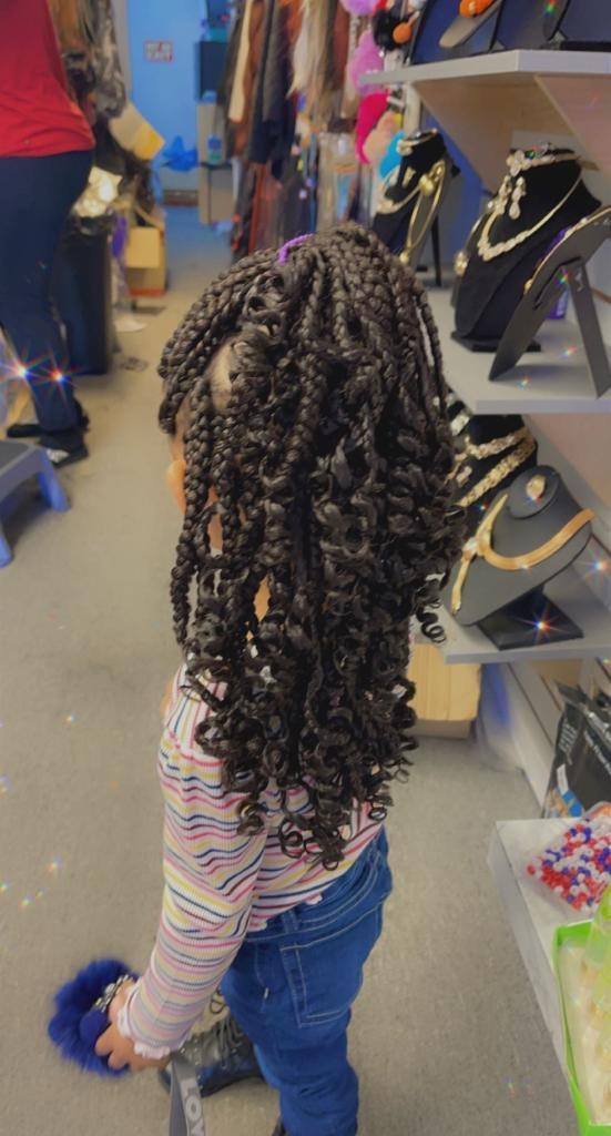 Child with long braids finished in curls