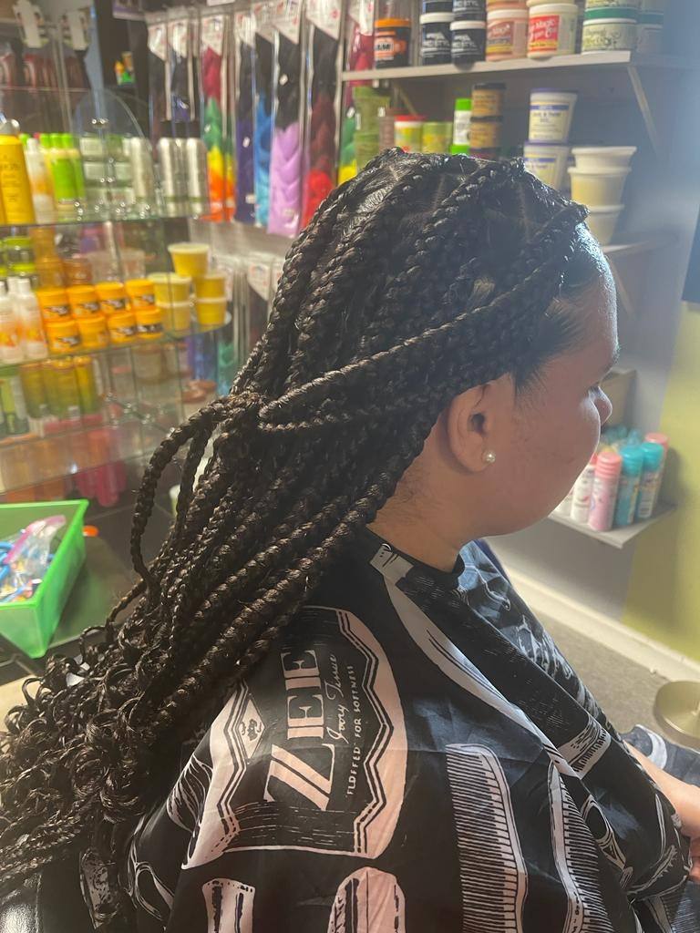 Long knotless braids styled in the salon, side view